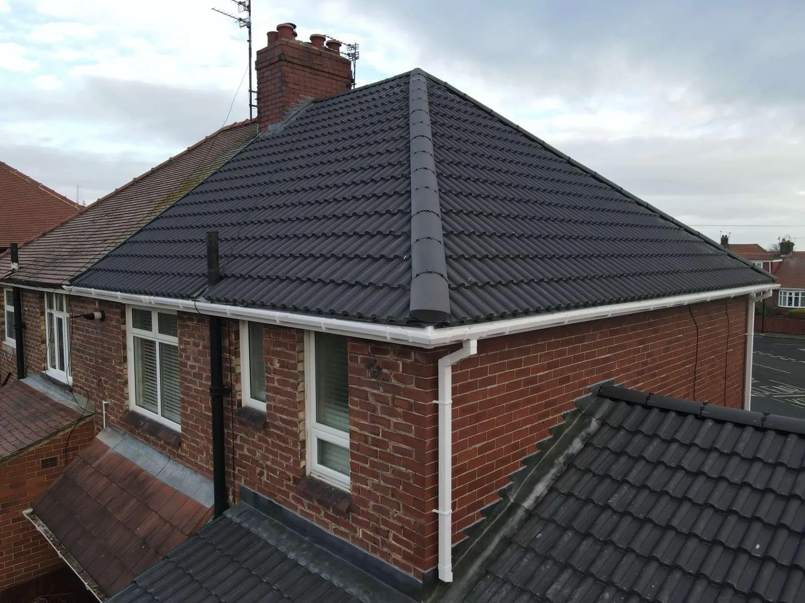 Modern dark roof on a brick house
